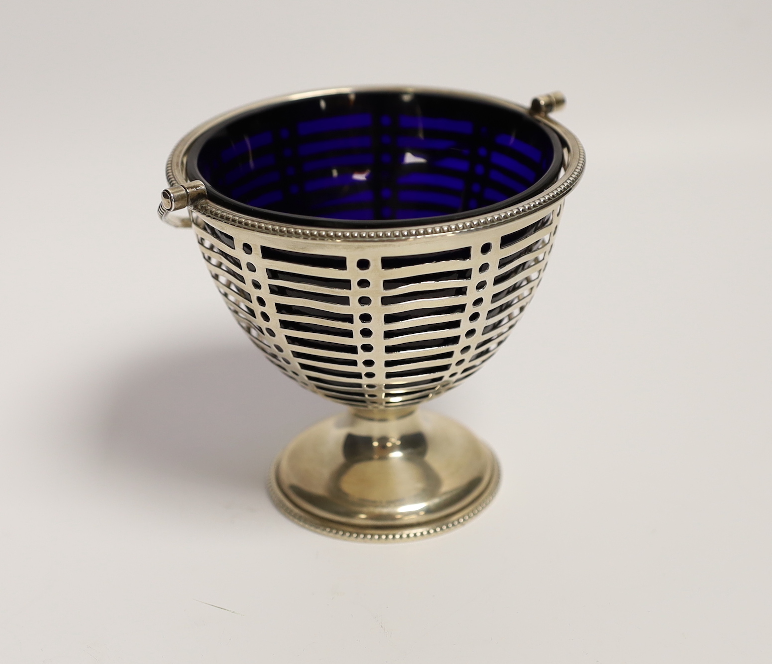 A George V pierced silver sugar vase, with blue glass liner, Barker Brothers, Chester, 1910, height 85mm.